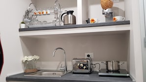 A kitchen with a sink, a toaster, and a kettle on the countertop. - Tre Stelle al Duomo (Catania)