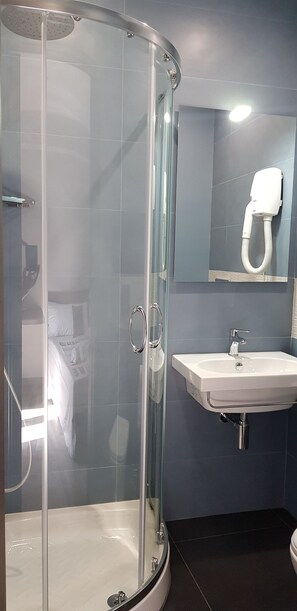 A modern bathroom with a glass-enclosed shower, a white sink, and a mirror above the sink. - Tre Stelle al Duomo (Catania)
