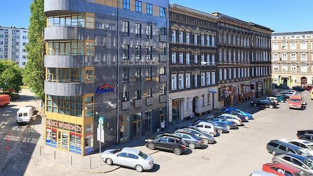 Un edifici de diverses plantes amb un disseny modern, caracteritzat per grans finestres i una estructura de terrat singular.