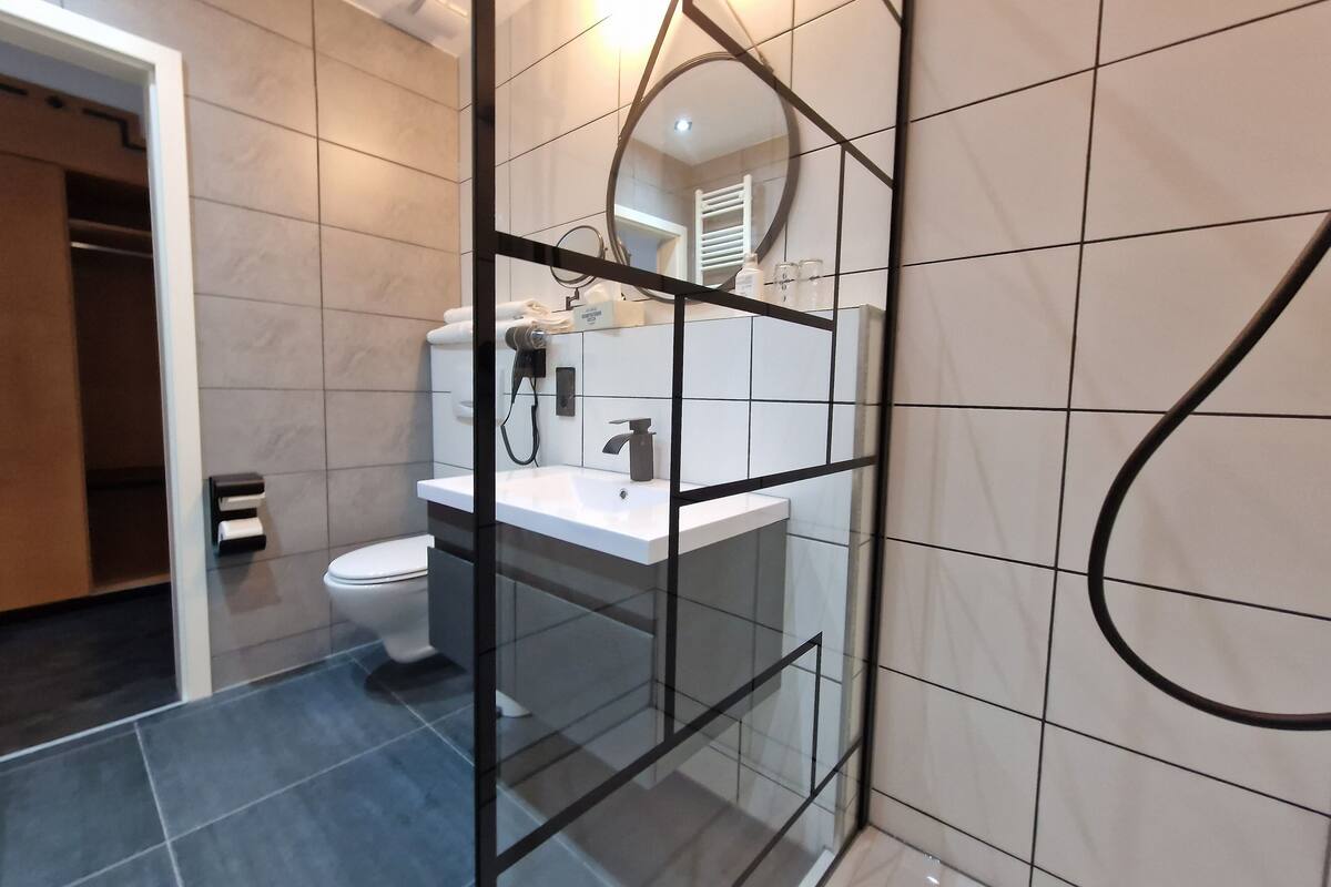 junior suite | bathroom | shower, hair dryer, towels, soap