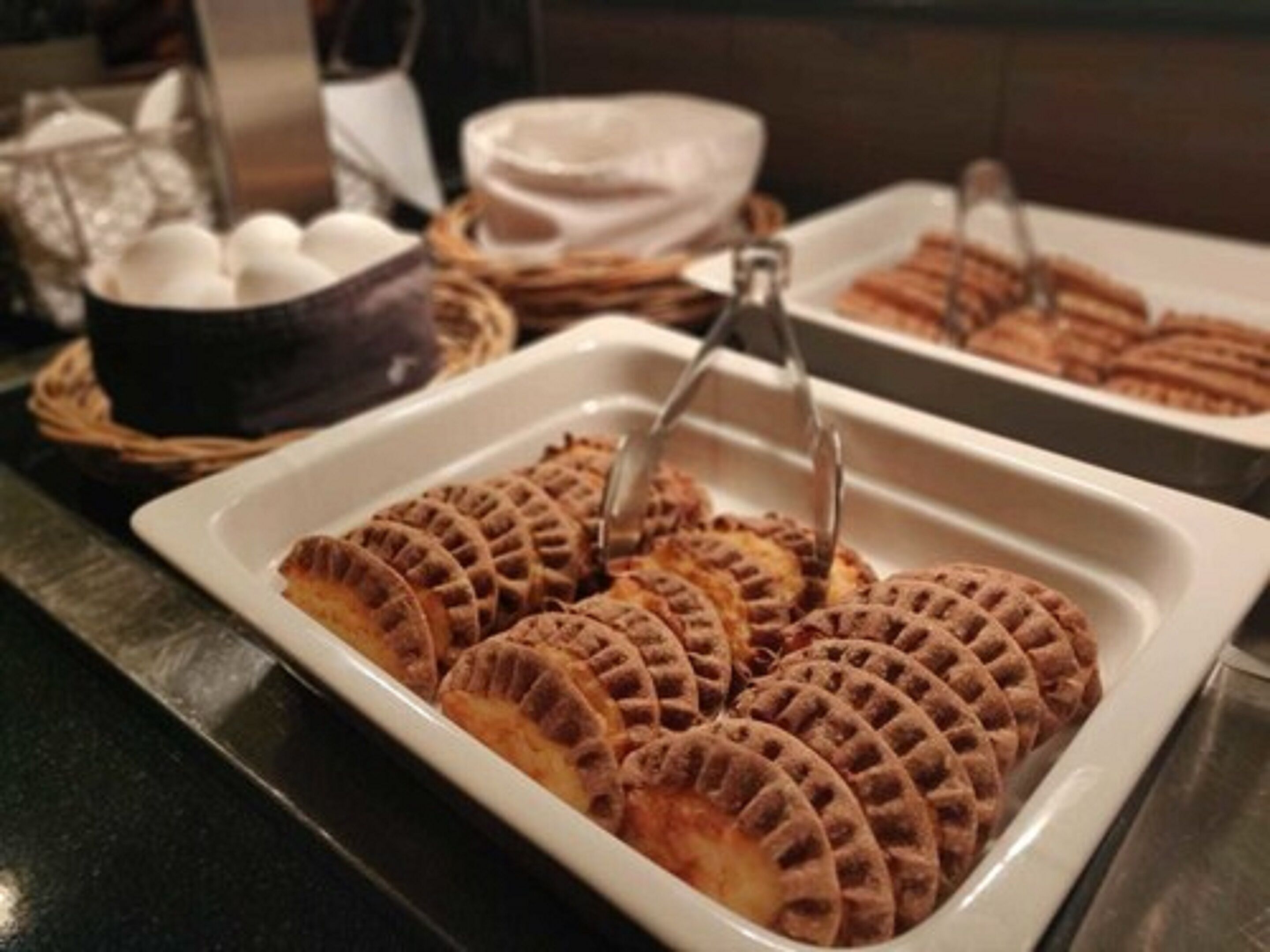 A buffet with waffles and other baked goods.