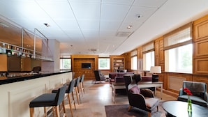 A spacious hotel lobby with a bar area, seating, and large windows. - Hämeenkylä Manor (Vantaa)