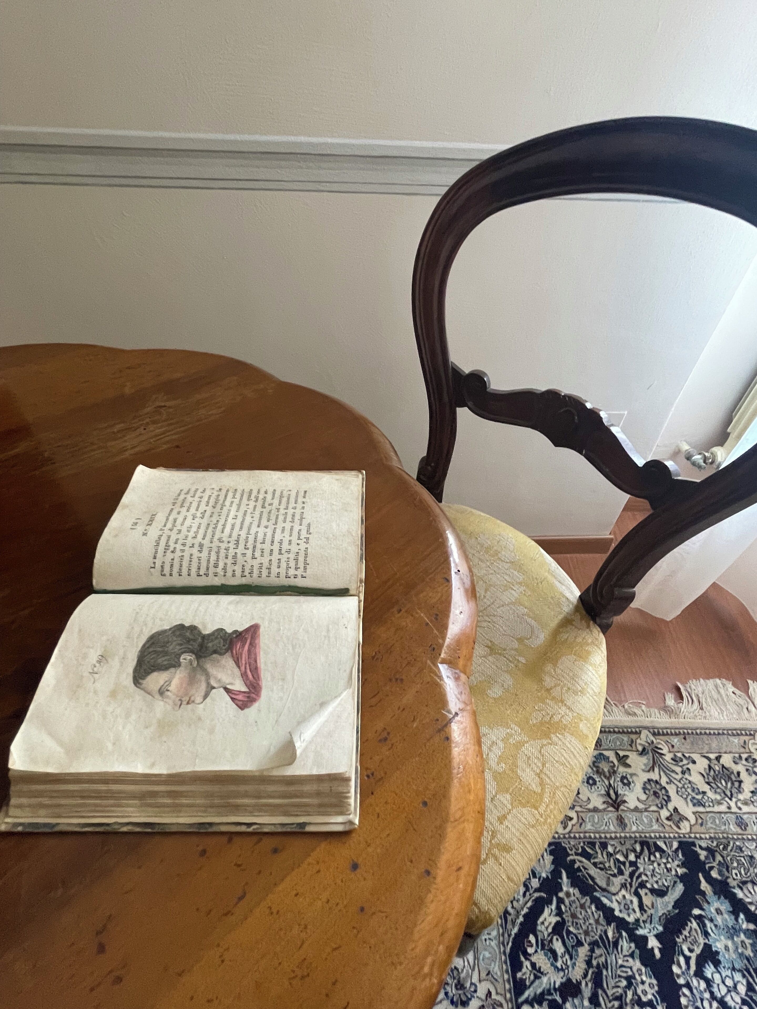 An open book with text and a drawing on a wooden table.