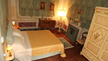 Un dormitorio con cama, cómoda, mesita de noche, lámpara y espejo.