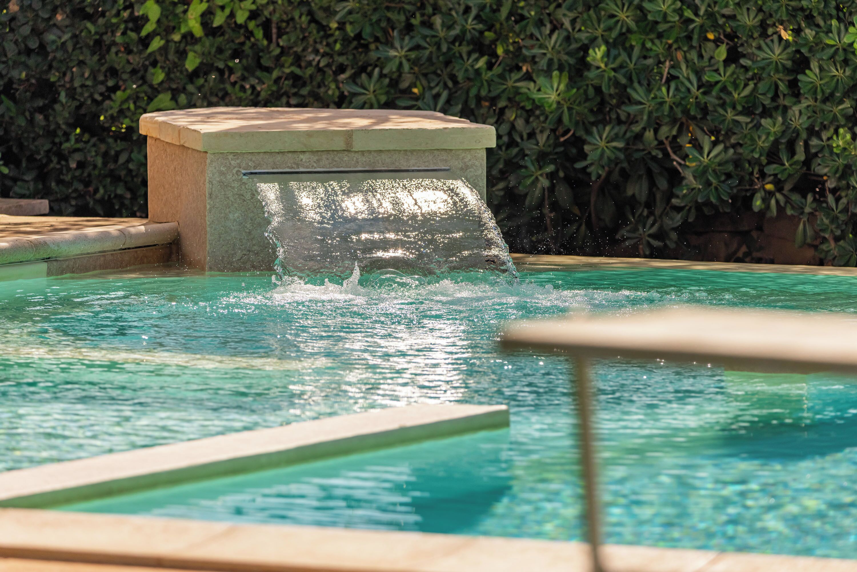 Una piscina amb una font, envoltada per un setiller.