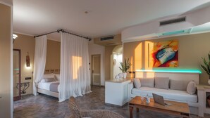 A modern hotel room with a bed, a sofa, a coffee table, and a wicker chair. - Montecallini Hotel - Adults Only (Patu)