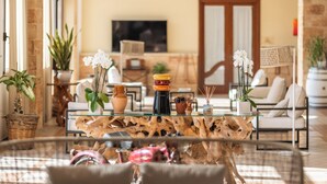 A modern living room with a glass coffee table, white sofas, and decorative plants. - Montecallini Hotel - Adults Only (Patu)