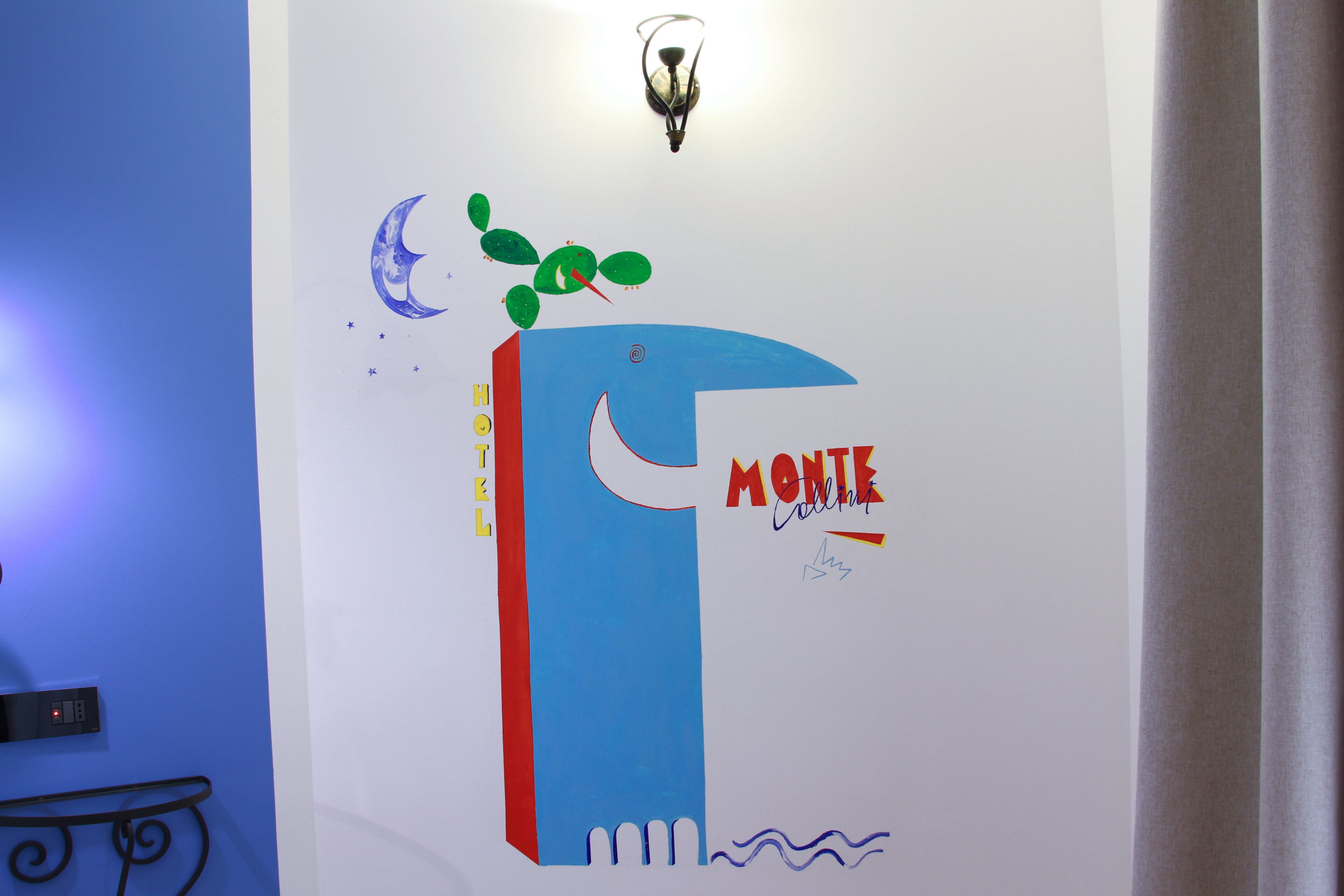 A wall with a large blue and red graphic, a crescent moon, and the text "HOTEL MONTE".