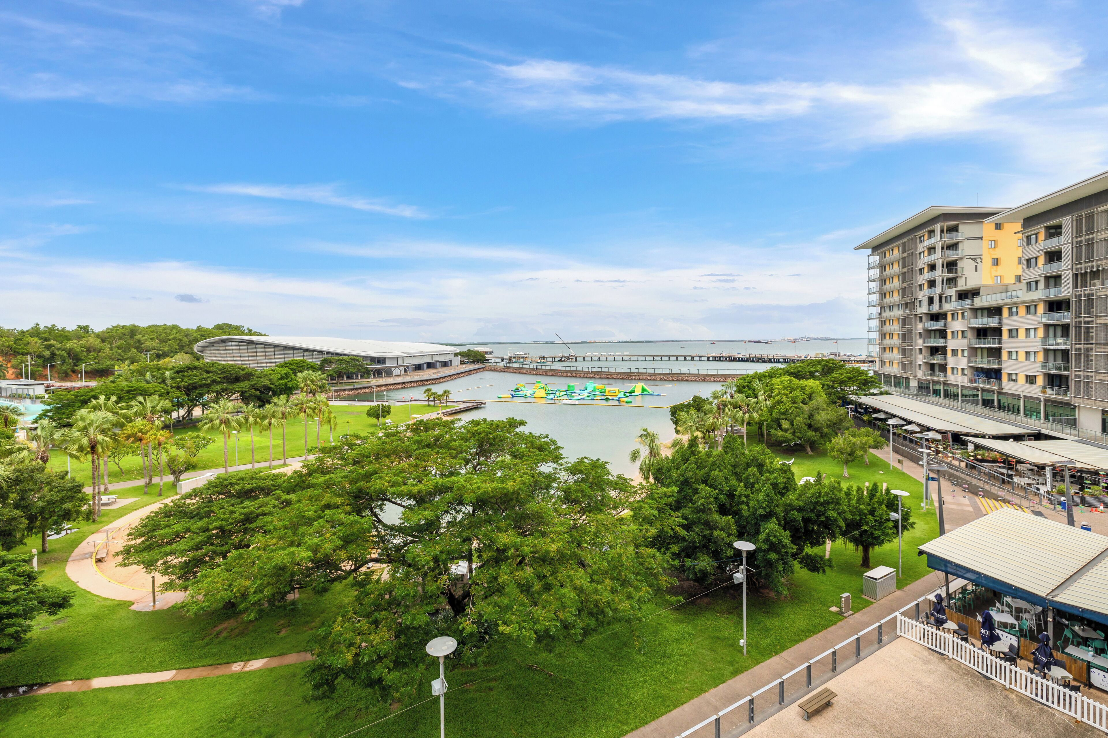 A hotel with a view of a water park, lush greenery, and a modern building structure.