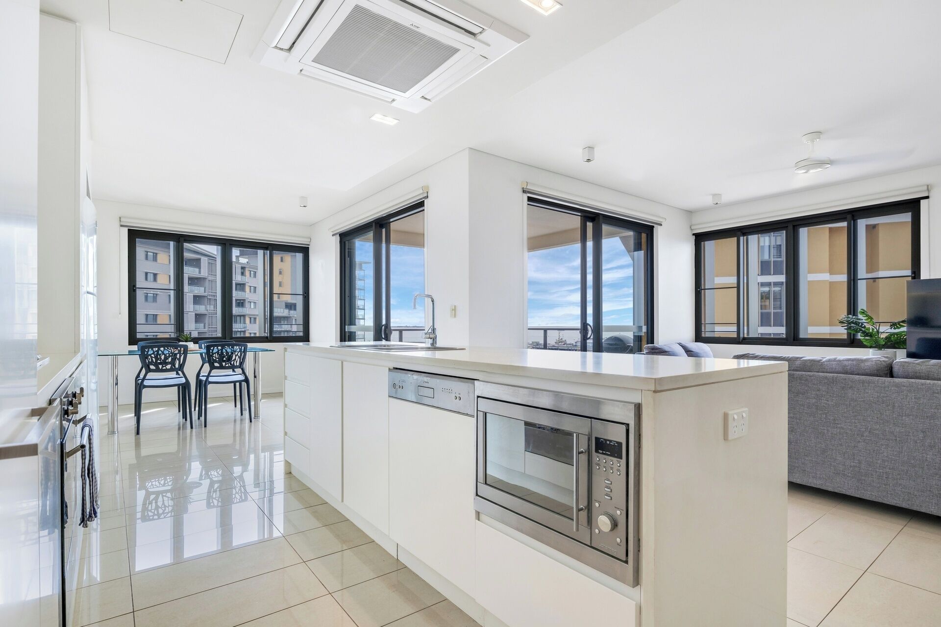 A modern kitchen with a dishwasher, oven, and large windows.