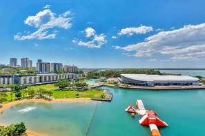 Vista al agua con un estadio grande, una piscina y varios edificios altos.
