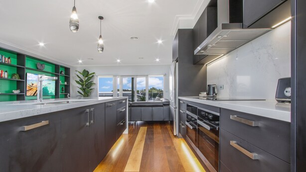A modern kitchen with dark cabinetry, stainless steel appliances, and a wooden floor. - The Apartment, Metung (Metung)