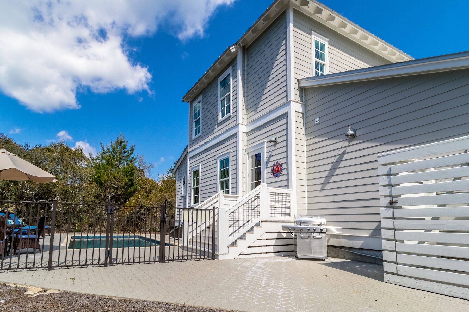 Ein zweistöckiges Haus mit Garage, Pool und überdachter Terrasse.