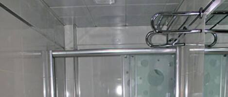A modern bathroom with a glass-enclosed shower, a white sink, and a toilet.