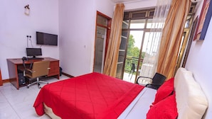 A bedroom with a bed, a desk with a computer, a TV, and a balcony with curtains. - Frontiers Hotel Entebbe (Entebbe)