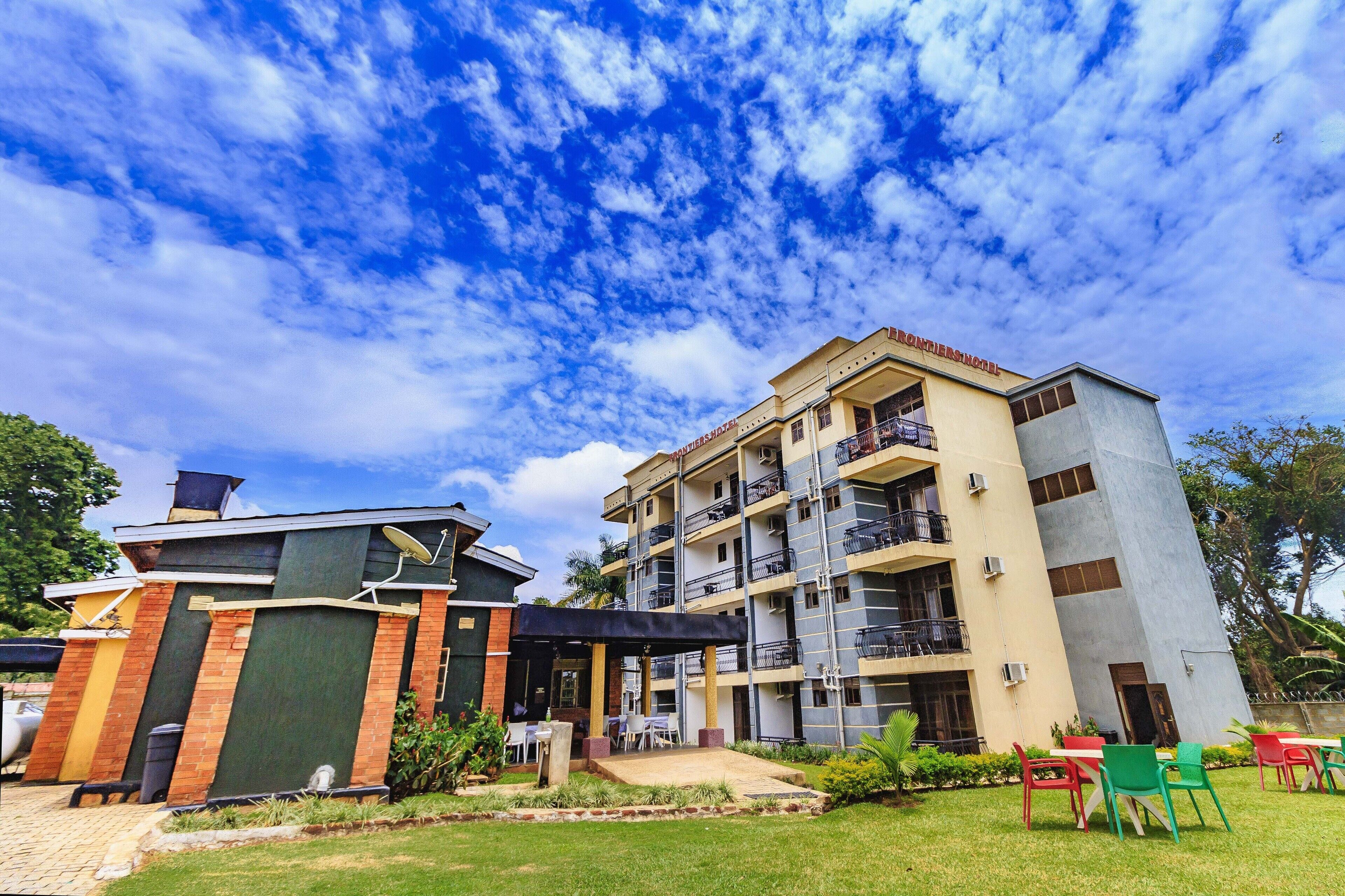 A multi-story building with a covered outdoor seating area and a garden.