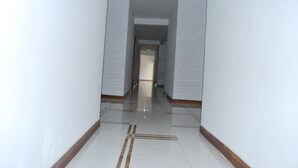 A narrow, well-lit hallway with white walls and a shiny tiled floor. - Frontiers Hotel Entebbe (Entebbe)
