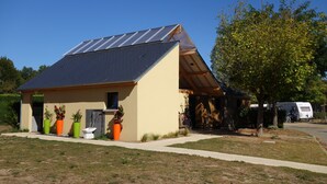 Ein modernes Haus mit geneigtem Dach, Solaranlagen und einer überdachten Veranda.