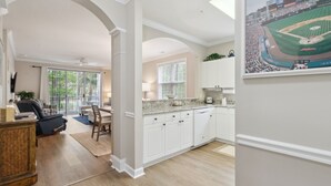 A spacious kitchen with white cabinetry, a granite countertop, and a large window. - River Crossing #1224 2 Bedroom Condo by RedAwning (North Myrtle Beach)