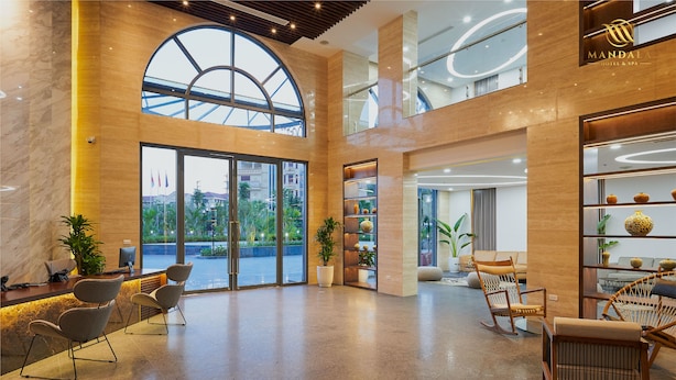 A spacious lobby with a high ceiling, large windows, and a modern interior design. - Mandala Hotel and Spa (Vu Ninh)