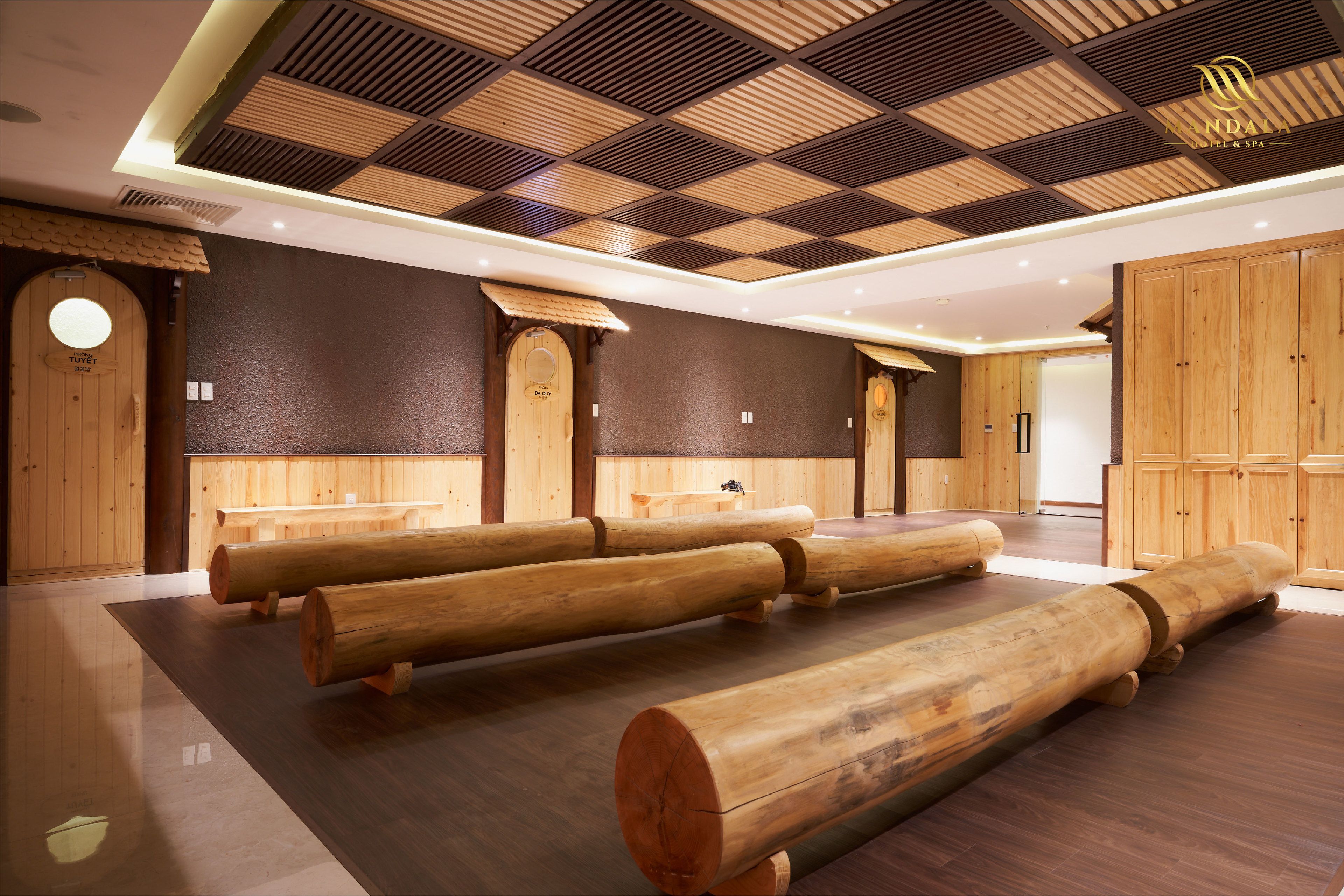 A spa area with wooden massage tables, a checkered ceiling, and wooden panel walls.