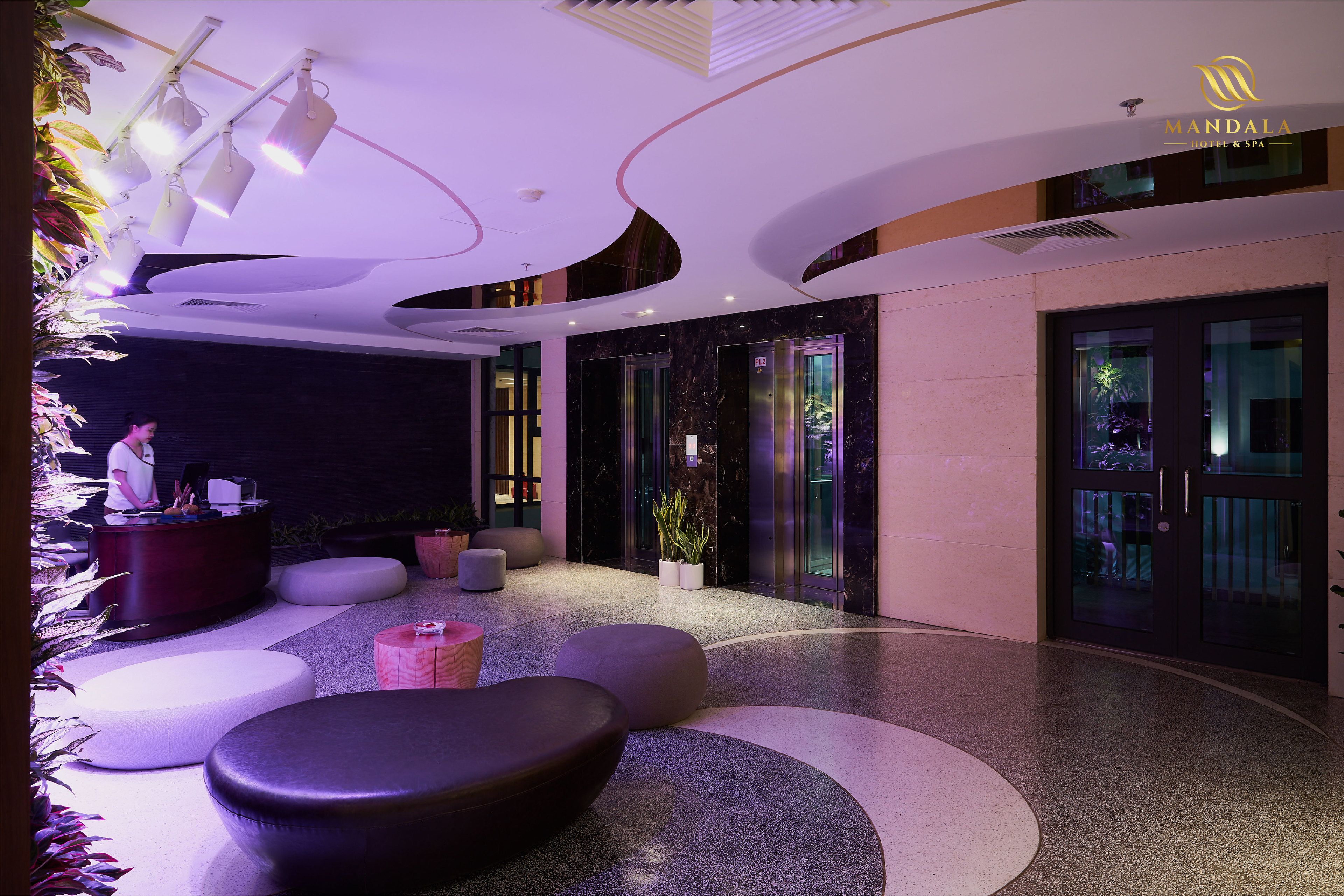 A modern lobby with a reception desk, seating areas, and a glass door entrance.