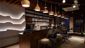 A bar area with wooden ceiling beams, hanging pendant lights, and bar stools. - Mandala Hotel and Spa (Vu Ninh)