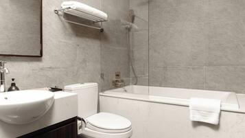 A modern bathroom with a toilet, sink, and bathtub.