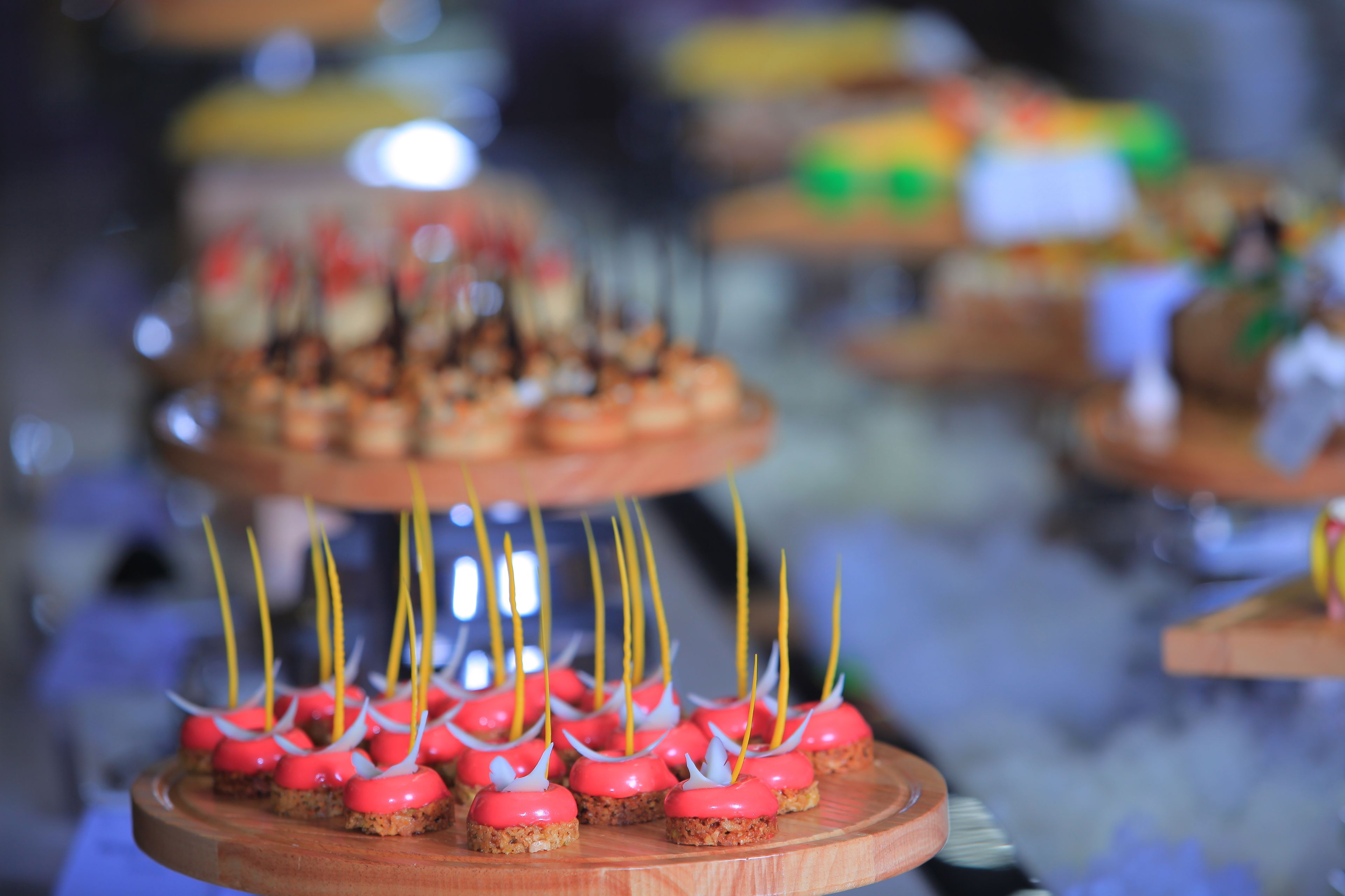 Una presentación de postres con varios niveles, cada uno con una decoración particular.
