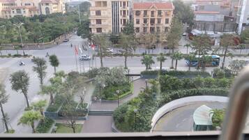 A view of a city intersection with buildings, trees, and a pedestrian walkway.