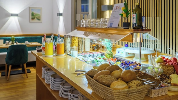 A buffet setup with various food items, a pineapple, and a selection of beverages. - Stadthotel Pfeffermuhle (Gengenbach)