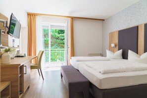 A hotel room with a bed, a desk, a chair, and a television. - Stadthotel Pfeffermuhle (Gengenbach)