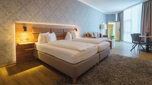 A hotel room with two beds, a desk, and a chair. - Stadthotel Pfeffermuhle (Gengenbach)