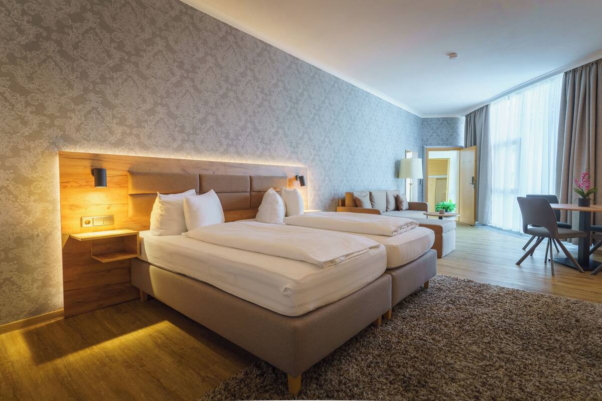 Una habitación de hotel con dos camas, un escritorio y una silla.