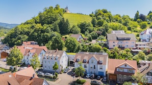 A residential area with traditional European architecture, including houses with sloped roofs and a church on a hill. - Stadthotel Pfeffermuhle (Gengenbach)