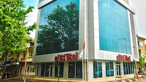 A hotel with a modern glass facade, multiple entry points, and a visible outdoor seating area. - Aksehir Elitt Hotel (Aksehir)