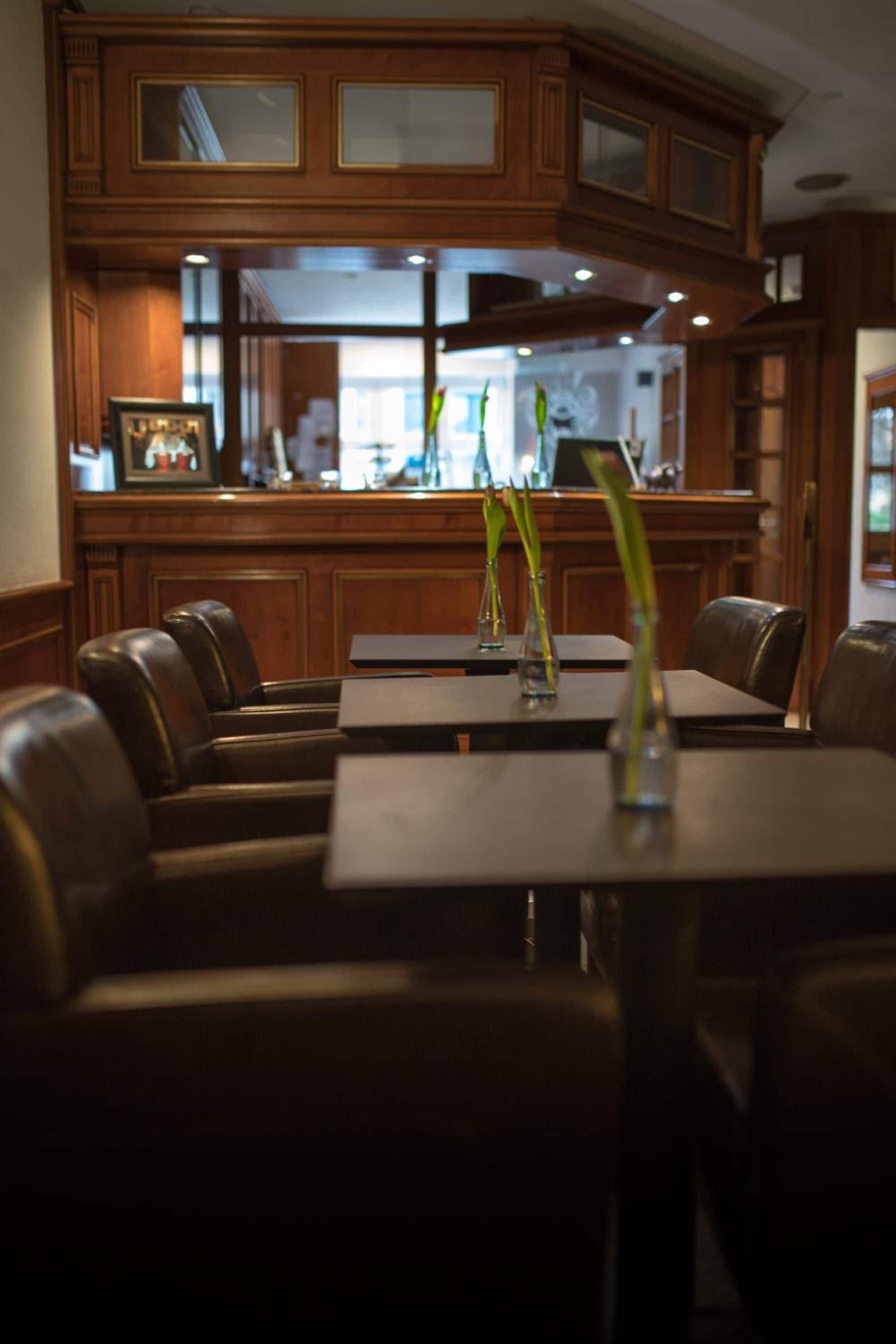 A restaurant interior with wooden paneling, a bar area, and seating arrangements.