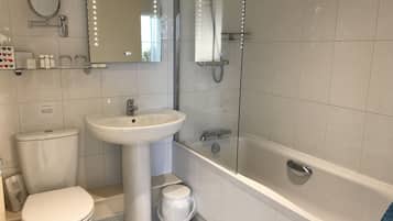 Un baño con inodoro, lavamanos pedestal y ducha a pie.