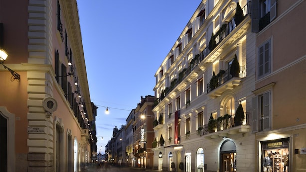 Une rue bordée de bâtiments historiques, dont un hôtel qui affiche une enseigne sur laquelle on peut lire « HÔTEL ».