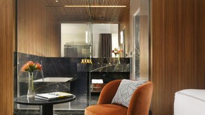 Une salle de bain moderne avec un meuble-lavabo en marbre, une cabine de douche en verre et un plafond en bois.
