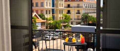 A balcony with a table, a chair, and a view of buildings.