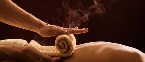 A person receiving a massage with a towel and steam.
