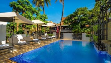 Una piscina al aire libre, sombrillas