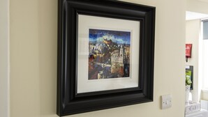 A framed cityscape artwork on a wall. - Stunning Studio Apartment Castle View (Edinburgh)