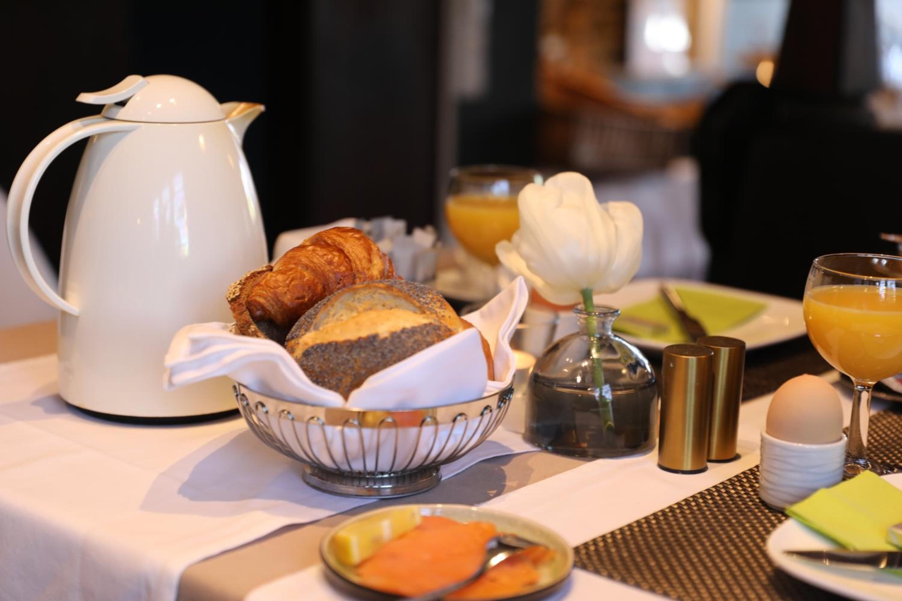 Desayuno con cruasanes, jugo de naranja y una cafetera.