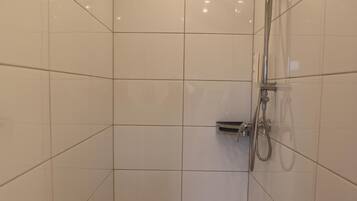 Ducha con cabezal de ducha de mano y grifo empotrado.