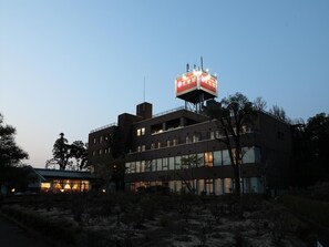 Een meerhoog gebouw met een opvallende reclameborden op het dak.