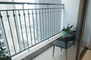 Ein Balkon mit Metallgeländer, einem Blumentopf und einem Stuhl.