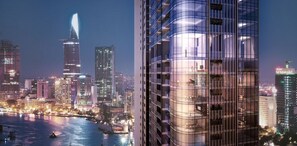 A modern high-rise building with a glass facade and balconies, set against a city skyline at night. - Jack Hai Vinhome Apartment (Ho Chi Minh City)