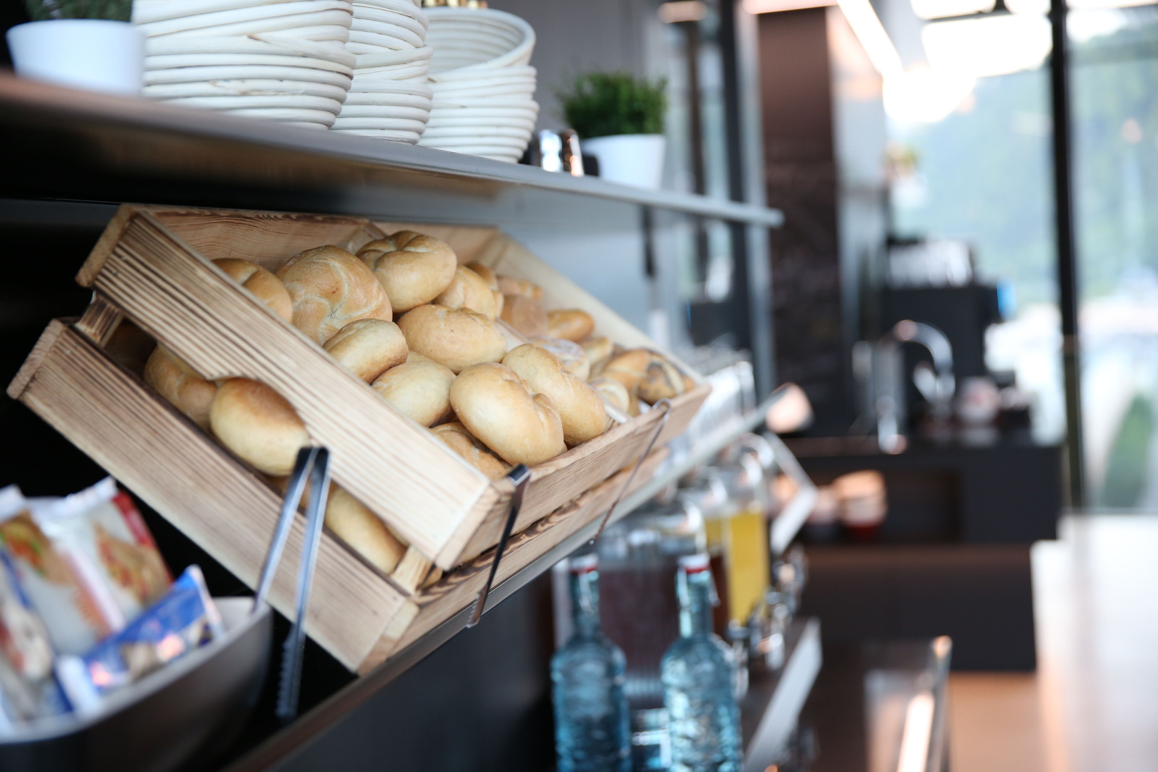 A bakery display with bread and pastries, a coffee machine, and bottled beverages.